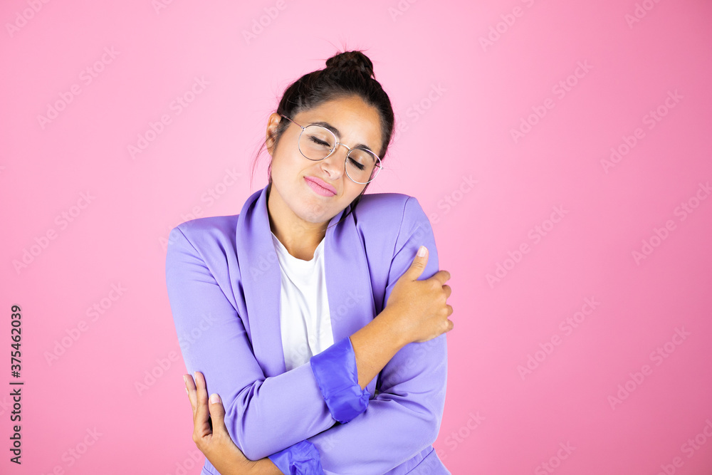 Young beautiful business woman over isolated pink background hugging oneself happy and positive, smiling confident Young beautiful business woman over isolated pink background hugging oneself happy and positive, smiling confident