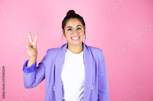 Young beautiful business woman over isolated pink background showing and pointing up with fingers number two while smiling confident and happy