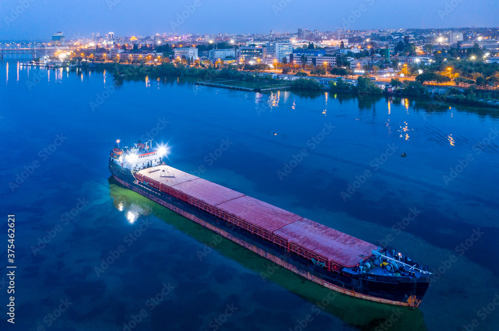 Large black dry cargo ship anchored on the Dnieper River awaiting loading with new cargo