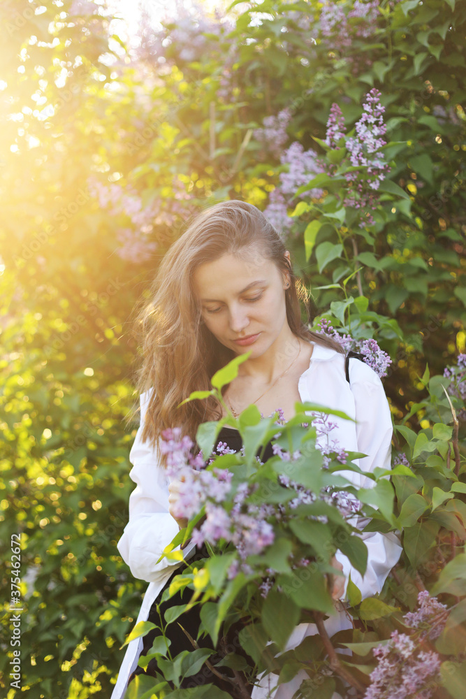 unreal stunning beautiful young woman walking in a green flowered in spring in a lavender garden with a bouquet of lilac in the hands. Closeup fashion romantic portrait. smelling the flowers unreal stunning beautiful young woman walking in a green flowered in spring in a lavender garden with a bouquet of lilac in the hands. Closeup fashion romantic portrait. smelling the flowers