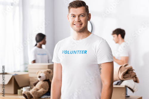 Selective focus of young volunteer looking at camera in charity center