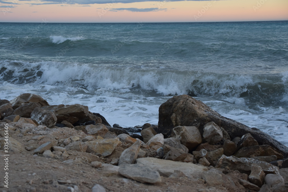 Atardecer con olas del mar mediterráneo con horizonte