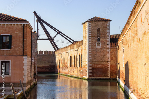Rio de le Vergini, Venice. The river, which borders a stretch of the walls of the Arsenale. View on the beautiful crenellated walls of Arsenale illuminated by sun.