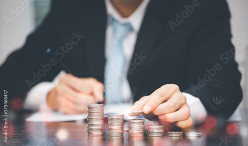 Businessman touch coins with line connect and Coins stack on the wooden table , Saving ideas and investment budget, Creative ideas concept of saving money concept, Copy space