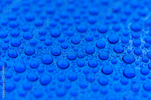 Close-up of drops of rainwater on blue metal background after nanoceramics polishing technology photo