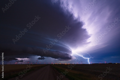 Supercell thunderstorm with lightning bolt in the night sky