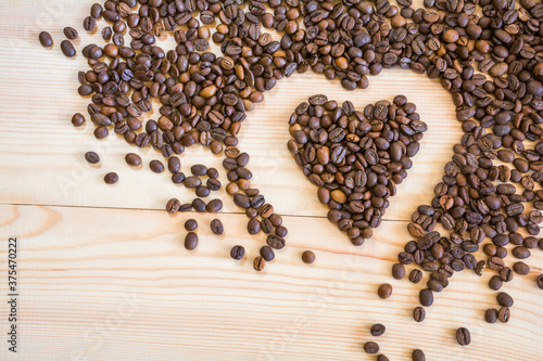 Coffee beans in the shape of a heart on a wooden background