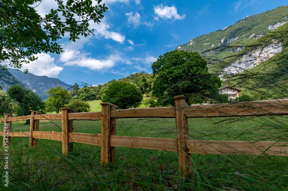 Summer panorama in the mountains and wooden fence near the lake of tenno, wine route, near Lake Garda, Riva del Garda, Trentino Alto Adige, Trento, Italy.