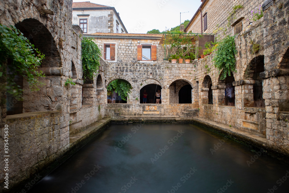 Stari Grad/ Croatia-August 7th,2020: Wonderful sea water pool with mullet fish, surrounded by stone arches in the 