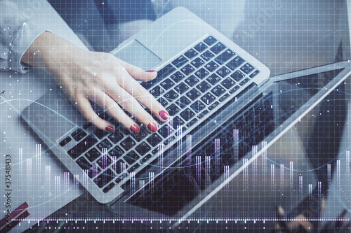 Double exposure of businesswoman hands typing on computer and financial graph hologram drawing. Stock market analysis concept.