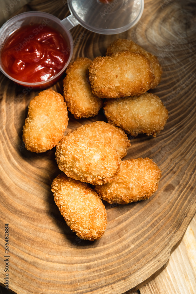 Chicken nuggets on a wooden board. Fast food concept Chicken nuggets on a wooden board. Fast food concept