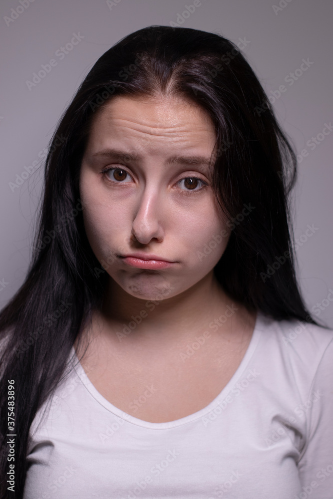 Close up portrait of pretty confident pensive thoughtful girl, looking seriously brunette. on grey background with copy space. People lifestyle concept Close up portrait of pretty confident pensive thoughtful girl, looking seriously brunette. on grey background with copy space. People lifestyle concept