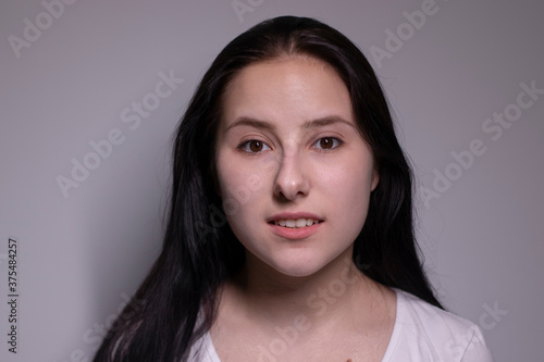 Young suprised brunette woman, isolated on gray background. happy girl actress portrait. The human emotions, facial expression concept