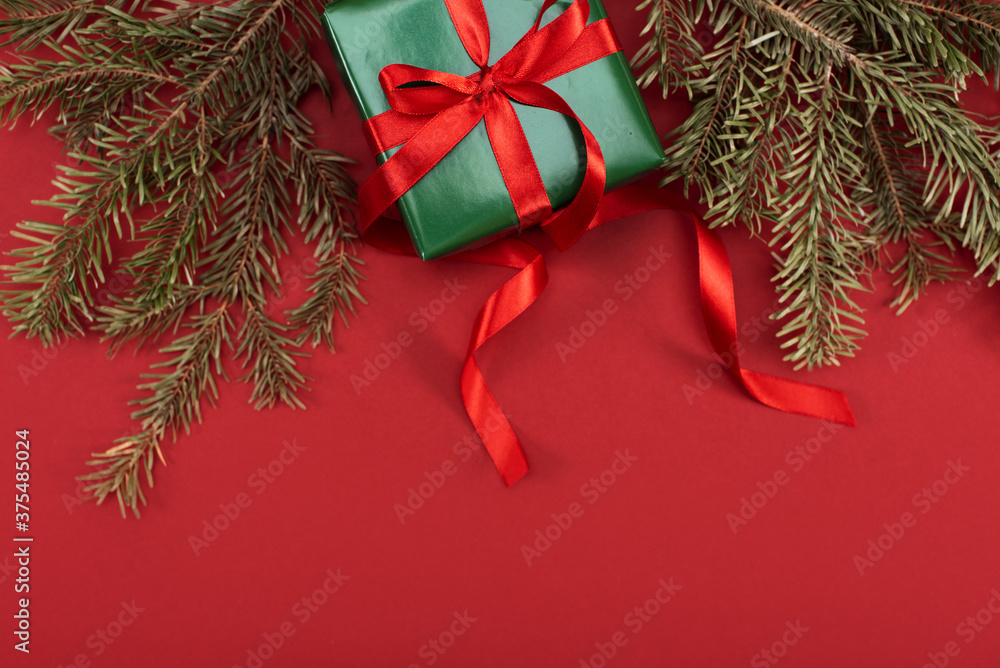 Christmas gifts, balloons, fir branches and candy cane on a red background, place for text