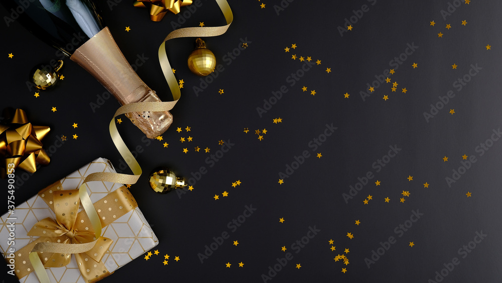 Naklejka premium Premium luxury Christmas background with champagne bottle, gift box, party streamers, golden confetti stars on black. Flat lay, top view, copy space. Christmas party banner mockup.