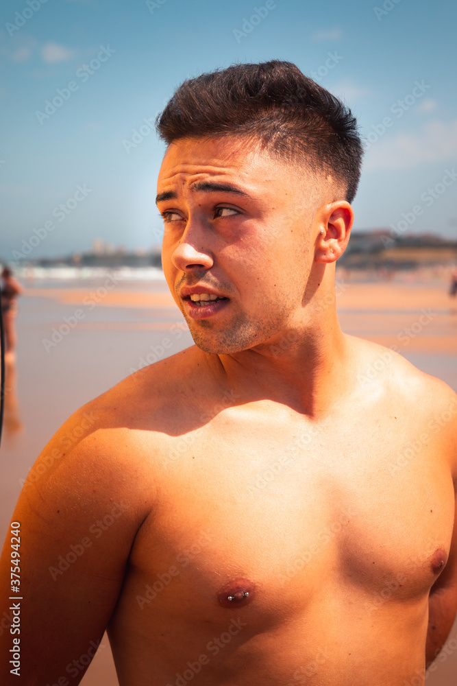 Young caucasian man posing at a beach in a summer morning in the basque coast. Young caucasian man posing at a beach in a summer morning in the basque coast.