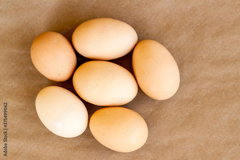 Organic,fresh large size uncooked eggs on kraft paper surface,top view Organic,fresh large size uncooked eggs on kraft paper surface,top view