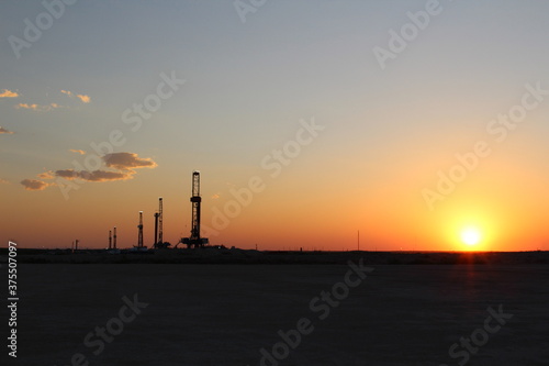 Rare image of the West Texas desert landscape during sunset with 5 drilling rigs in the background.