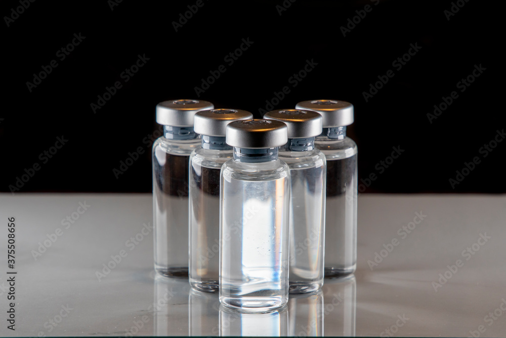 five vaccine containers with a black background to be used as coronavirus vaccine development five vaccine containers with a black background to be used as coronavirus vaccine development