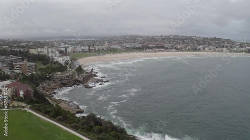 Aerial: Drone flying over Mackenzies Point towards Bondi Beach on a cloudy overcast day, in Sydney Australia  photo