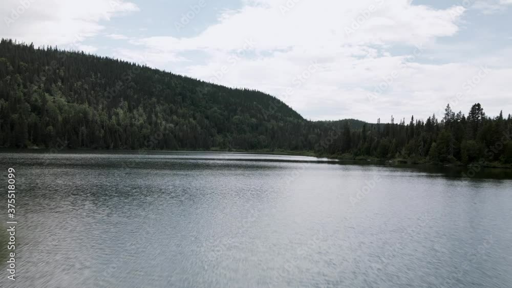 Overflying The Calm Water Of The Lost Lake With Lush Green Forest On The Mountains In Gaspesie Peninsula, Quebec, Canada. - aerial drone (forward) Overflying The Calm Water Of The Lost Lake With Lush Green Forest On The Mountains In Gaspesie Peninsula, Quebec, Canada. - aerial drone (forward)