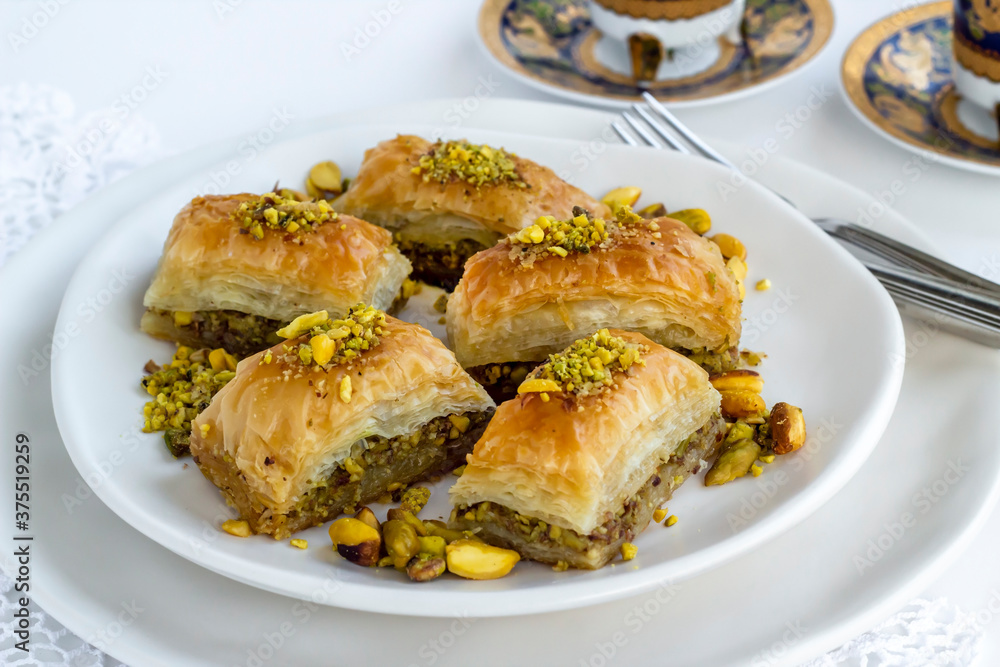 Traditional Turkish Pastry Dessert Baklava special designed on plate with pistachio nuts and cutlery set