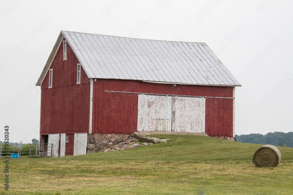 Obraz premium Red barn nestled in a hillside