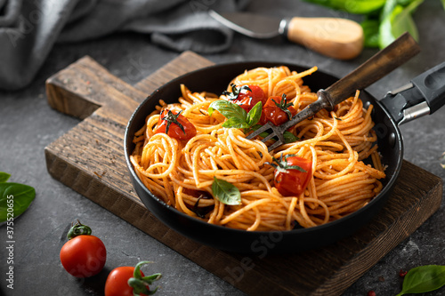 pasta in a black pan on a dark background , italian cuisine, selective focus