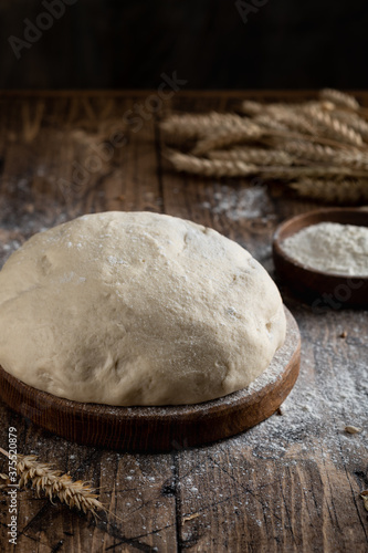 dough in an old bakery on a wooden background with flour