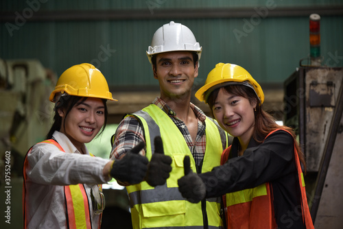 Group of technician man and industrial women worker with hard hat or helmet and vest jacket working electronic machinery and mechanical engineering in Factory of manufacturing place