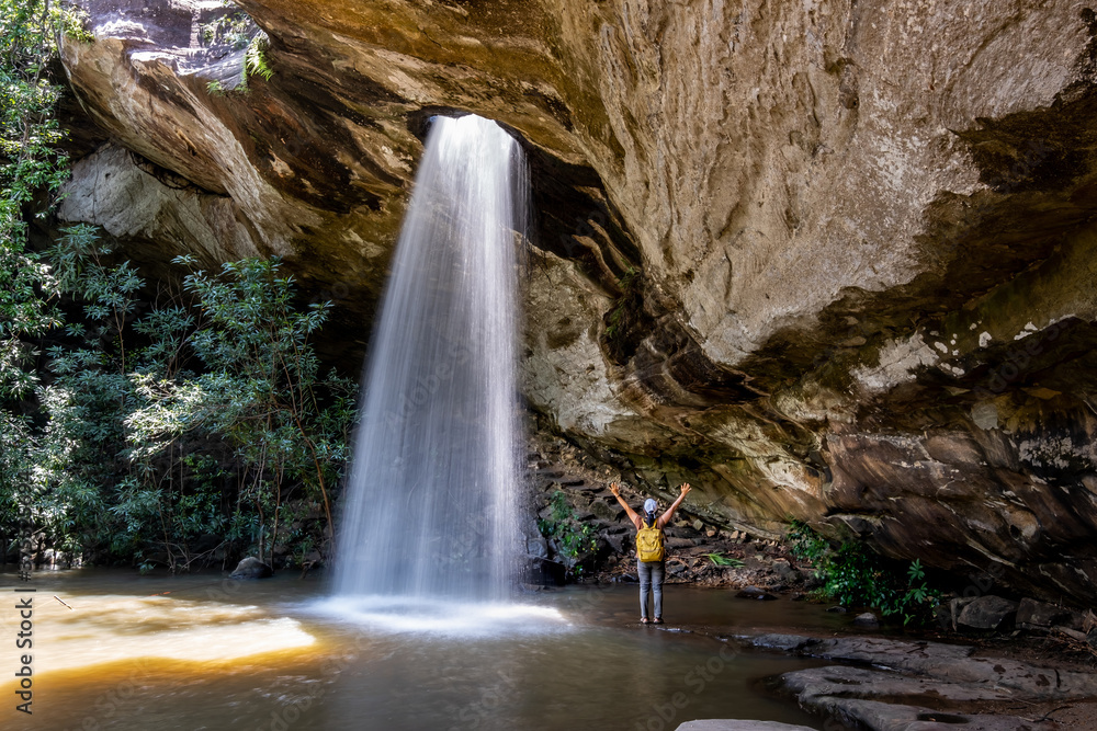 Fototapeta premium Woman standing in Saeng Chan Waterfall at Pha Taem National Park, Ubon Ratchathani, Thailand.