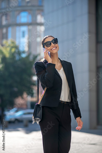 Elegant dark-haired woman talking on the phone