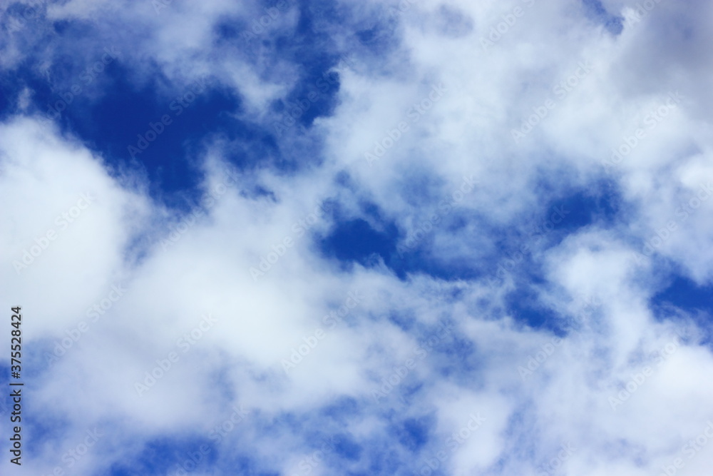 Moving white clouds across the blue spring sky. Seasonal bright sky