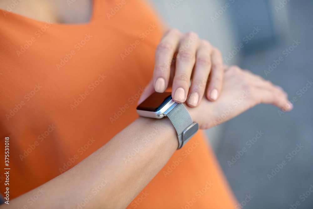 Close up picture of a womans hands and a smartwatch