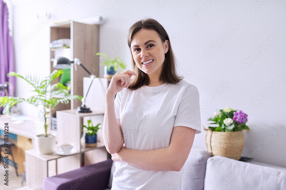 Portrait of happy smiling young woman looking at the camera in home Portrait of happy smiling young woman looking at the camera in home