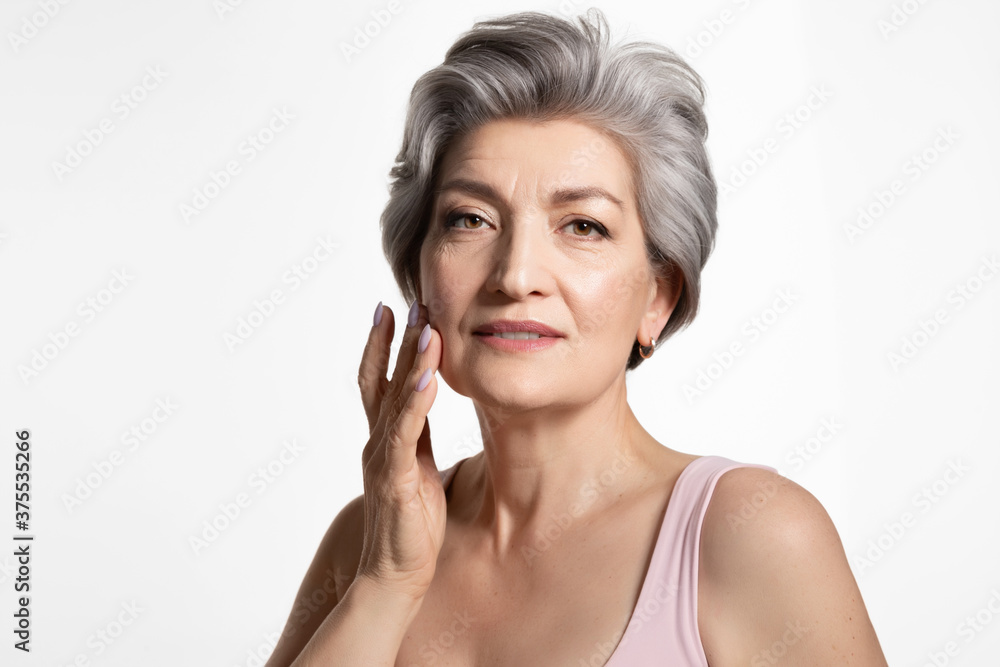 Old beautiful lady touching cheek with hand, enjoying perfect appearance. Skincare, cosmetology Old beautiful lady touching cheek with hand, enjoying perfect appearance. Skincare, cosmetology