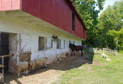 Colonial barn at the Hopewell Furnace National Historic Site in Pennsylvania. Massive, elegant whitewashed stone with wood above Dutch doors and ventilation windows. Notice the yoke on the wall. Full