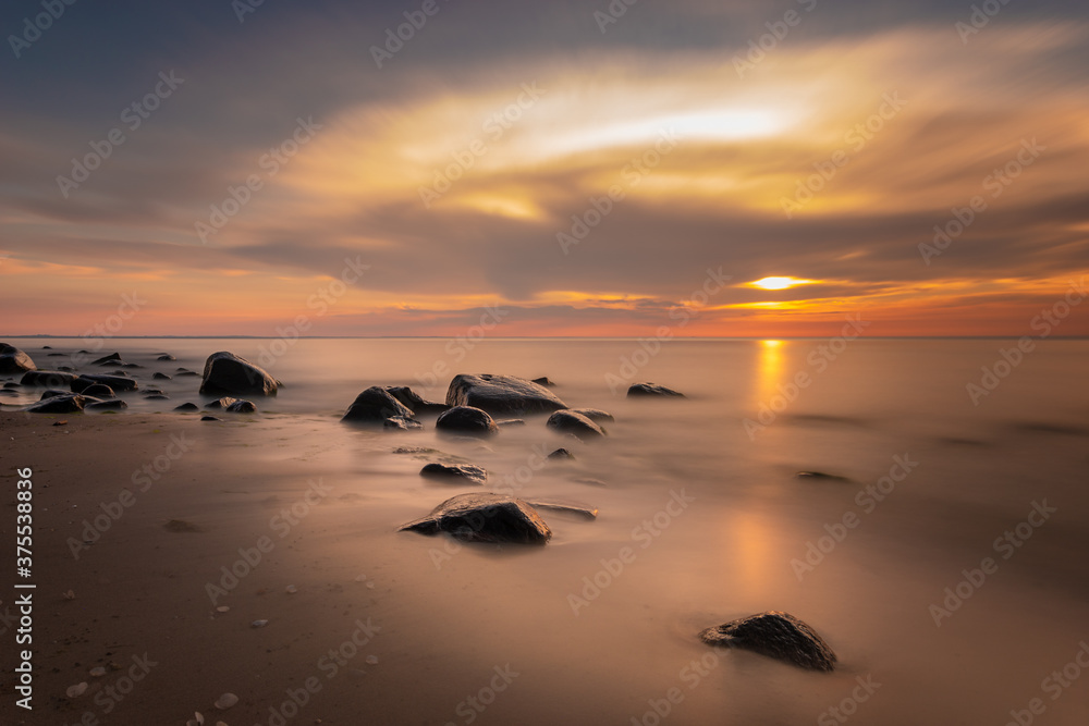 Boulders in the sea in the Wolin National Park in the light of the setting sun, Poland Boulders in the sea in the Wolin National Park in the light of the setting sun, Poland