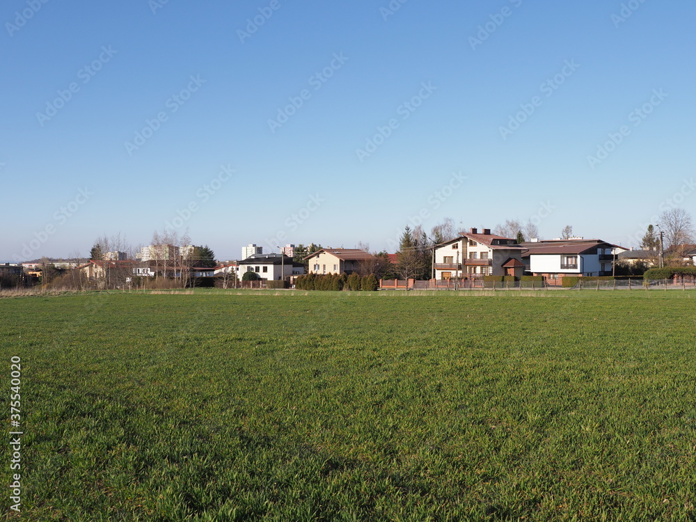Green terrain and houses at european Bielsko-Biala city in Silesian district in Poland, clear blue sky in 2020 warm sunny spring day on April. Green terrain and houses at european Bielsko-Biala city in Silesian district in Poland, clear blue sky in 2020 warm sunny spring day on April.