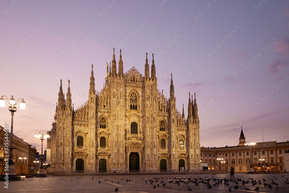 Facade of the beautiful historic Duomo building at night. Against the background of the sunset.