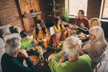Portrait of nice attractive adorable family parents grandparents sitting around served table eating meal dishes festal menu custom values at modern loft brick industrial interior house