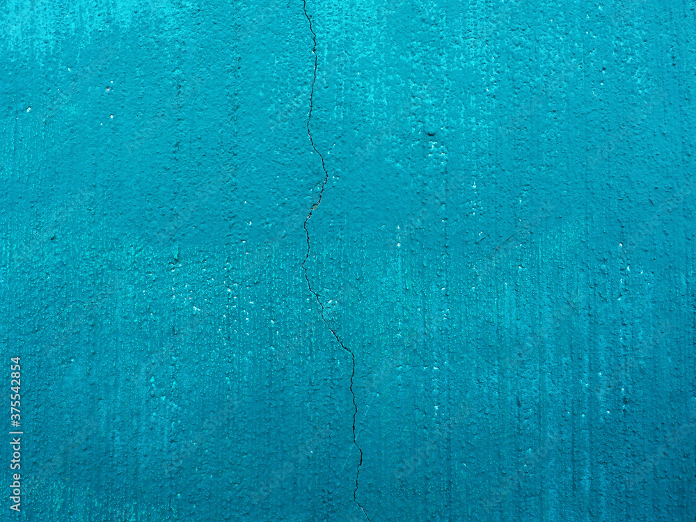 concrete wall painted with blue paint with crack