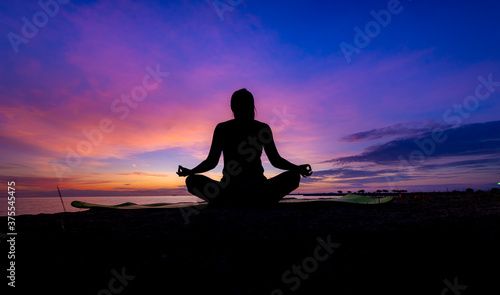 Fototapeta Naklejka Na Ścianę i Meble -  Silhouette woman make practice yoga and meditation for healthy with twilight sky background