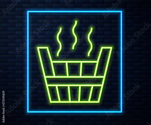 Glowing neon line Sauna bucket icon isolated on brick wall background. Vector.
