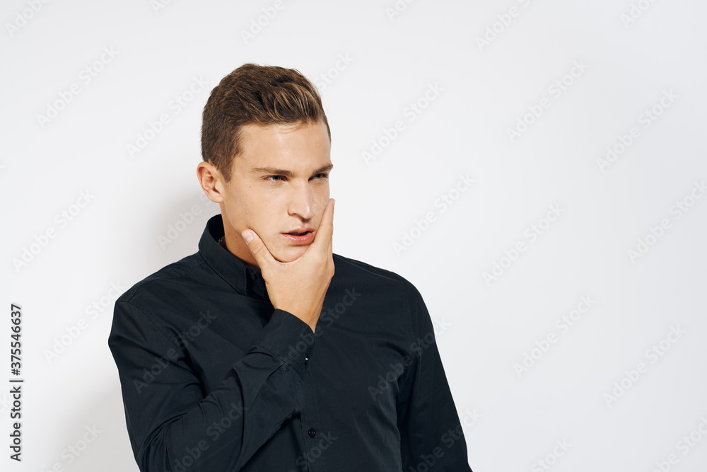 Man in black shirt lifestyle emotions modern style cropped view light background Man in black shirt lifestyle emotions modern style cropped view light background