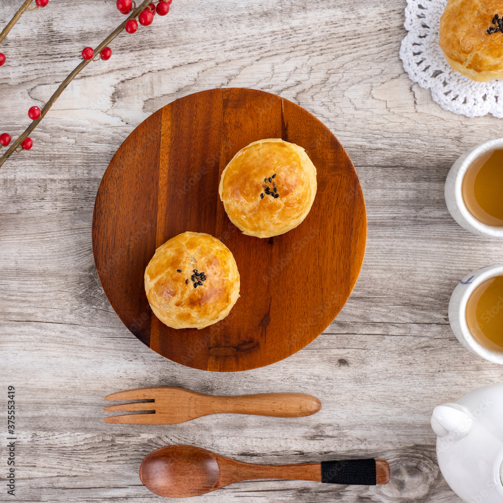 Moon cake yolk pastry, mooncake for Mid-Autumn Festival holiday, top view design concept on bright wooden table with copy space, flat lay, overhead shot Moon cake yolk pastry, mooncake for Mid-Autumn Festival holiday, top view design concept on bright wooden table with copy space, flat lay, overhead shot