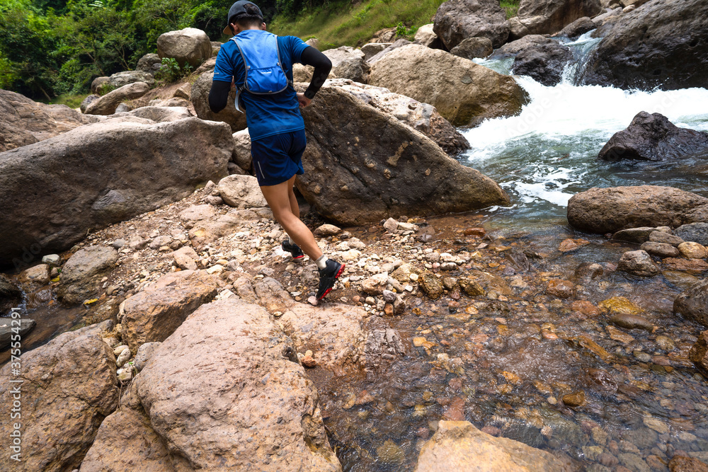 Runner, he's running a trail. In the natural path around the waterfall Runner, he's running a trail. In the natural path around the waterfall