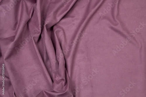 Ocher matte background of suede fabric, closeup. Velvet texture of seamless leather.