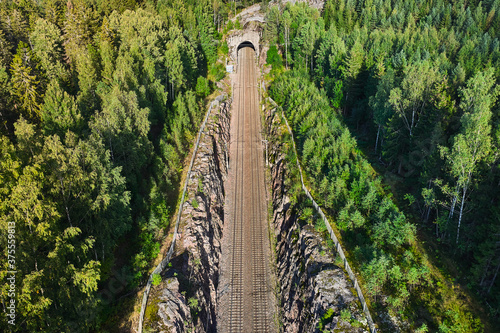 Obraz na płótnie Aerial view of the railway track. The railroad between the hills goes into a tunnel. w salonie