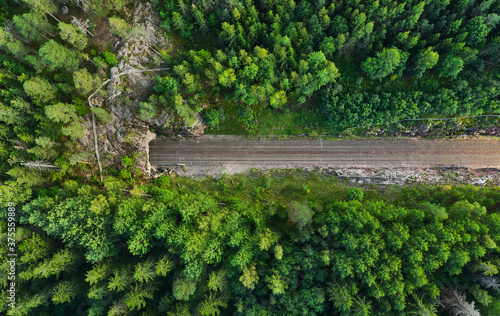 Aerial view of the railway track. The railroad between the hills goes into a tunnel.